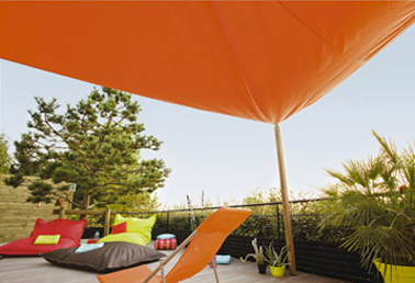 Faire la sieste sur sa terrasse à l'abri d'une grande toile d'ombre couleur Terra cotta en harmonie avec le salon de jardin. Photo Leroy Merlin