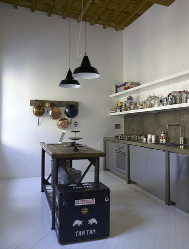 Style indusdriel pour une déco de cuisine couleur taupe, blanc et gris. Les meubles de cuisine gris bleuté sont encastrés dans une structure construite en carreaux de plâtre recouverts d'une peinture couleur taupe, couleur reprise pour le plan de travail en pierre et pour peindre le mur de la crédence.