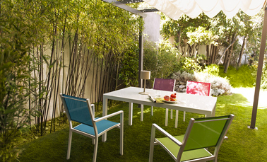 Fauteuils de jardin de couleur et table grise pour une déco de terrasse design. 4 couleurs de fauteuils : Rose, bleu, vert et violet de la collection Atlantis chez Castorama. 