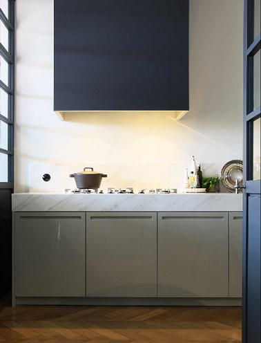 Une déco moderne pour une cuisine de maison de campagne avec une peinture pour les boiseries bleu électrique qui contraste avec le style authentique des meubles de cuisine taupe. 