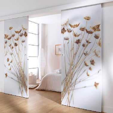 double porte tapissée et coulissante dans une chambre parentale La porte double vantaux coulissante en bois ou MDF se personnalise à souhait avec du papier peint pour créer l’ambiance zen dans cette chambre parentale. Les motifs légèrement doré sur fond blanc qui tapissent les coulissants invitent à pousser les portes pour savourer à loisir l’ambiance sereine qui règne dans la chambre. Vantaux et rails chez Lapeyre