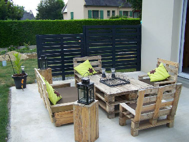 Un salon de jardin en palettes ultra facile à faire qui trouve naturellement sa place sur la terrasse ! La table basse se compose de deux palettes simplement superposées pour obtenir une bonne hauteur à l'heure de sortir les verres pour l'apéro. Les fauteuils sont fabriqués partir d'une palette bois coupée en deux pour l'assise, une autre légèrement en biais forme le dos du fauteuil. La banquette est fabriquée sur le même principe d’assemblage avec cette fois deux palettes bois sur la longueur. 