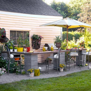fabriquez un coin bar dans le jardin avec des pieds en parpaings scellés dans le sol et recouverts d'un comptoir en bois exotique. Pour l'entretien, juste une huile pour teck sur le plateau une fois par an.