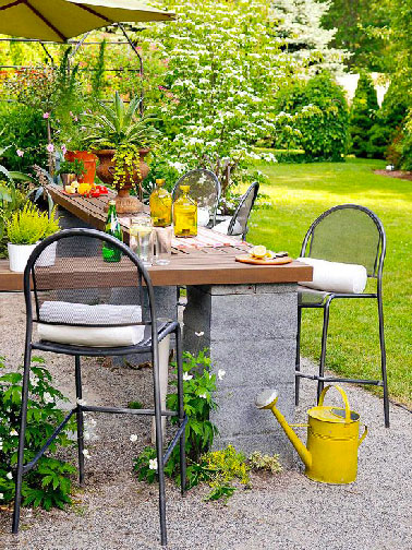 Sur les pieds en parpaing le plateau de la table de jardin en teck apporte le côté chic