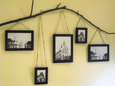 Pour une déco originale des cadres photos dans le salon, une branche d'arbre set de support aux cadres qui sont suspendus à différente hauteur à l'aide du corde.