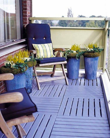 aménager un balcon avec une déco tout en bleu et vert: au sol, caillebotis peint bleu lavande assorti à la couleur des jarres. Pour profiter du soleiln deux fauteuil en teck et coussins bleu marine