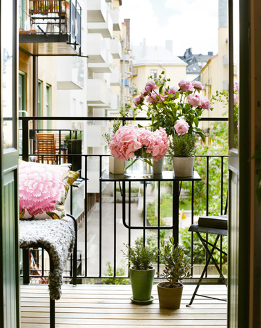 Un tout petit balcon aménagé en prolongement du séjour avec des touches de vert et rose pour l'égayer