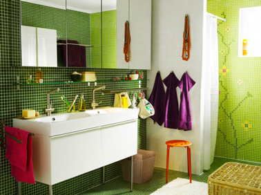 Couleurs pop pour une salle de bain Ikea avec une mosaïque verte et le linge de bain prune en contraste avec les meubles blancs