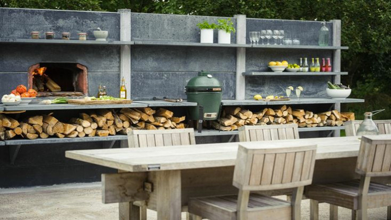 idée de cuisine extérieure à aménager avec barbecue four à pizza et salon de jardin en bois