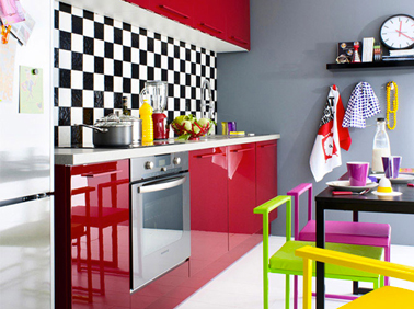 Modèle de cuisine rouge de Fly à installer avec une crédence en carrelage noir et blanc et des chaises vert anis et fushia pour une ambiance pop