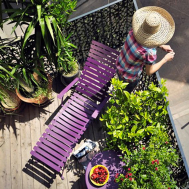De la couleur pour aménager un petit balcon apportée avec un transat et une petite table couleur violet pour faire un contraste avec les plantes vertes