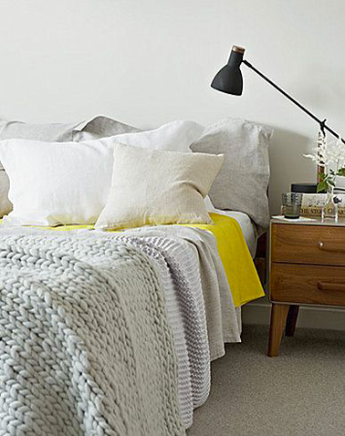 Dans cette chambre couleur lin en total look, loin d'être un intrus, le drap jaune apporte une note de fraicheur vivifiante