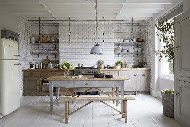 l'élégance d'une cuisine grise dans une maison de campagne Elégance et simplicité se conjuguent pour cette cuisine grise restaurée avec goût dans la maison de campagne, mêlant meubles gris et bois clair et un discret joint gris perle pour le carrelage blanc style métro. Les portes du placard sont repeintes en gris souris pour apporter un léger contraste avec le parquet repeint pour l'occasion