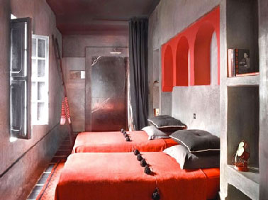 Couleurs décoration chambre béton ciré gris aux murs linge de lit couleur rouge et gris anthracite dans un esprit riad marocain zen plein de charme