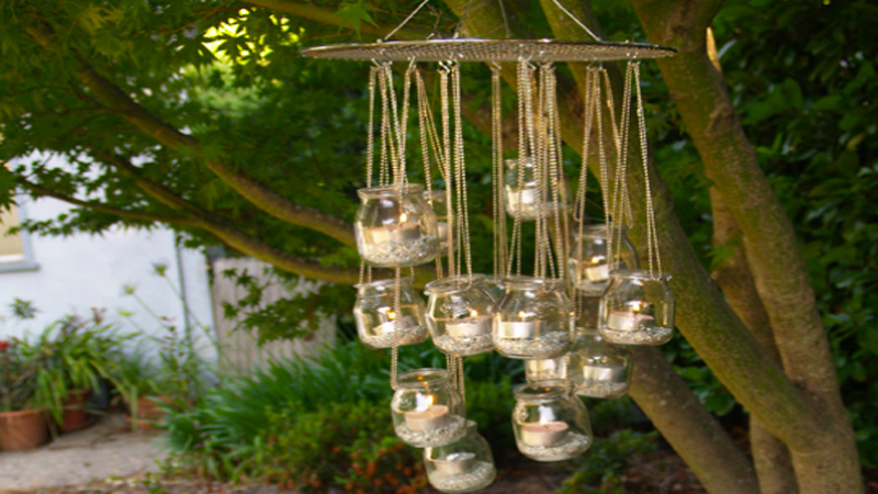 DIY pour fabriquer soi-même des lampions d'extérieur illuminés par des bougies posés dans des pots de verre et à suspendre sans retenue dans les arbres du jardin.