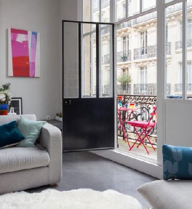 Du gris dans un salon en ville pour assurer la luminosité et du bleu en touche. La peinture gris perle, les fauteuils dans la même nuance, un tapis blanc, l'accord parfait. 