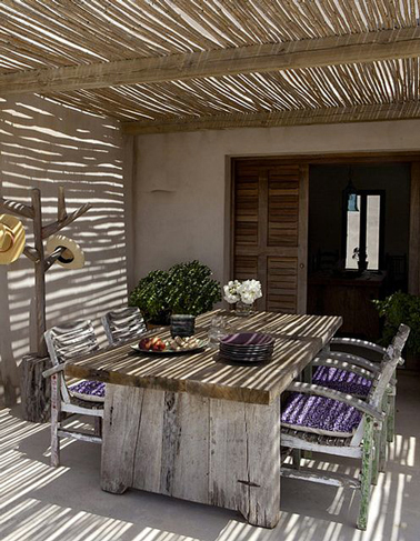 Pergola toit canisse de bambou montée sur structure poteaux bois pour protéger terrasse devant maison