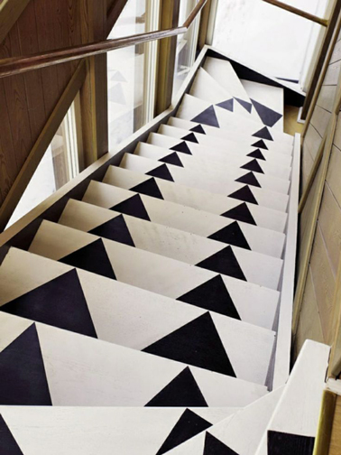 escaliers en bois repeints avec motifs noir et blanc Des triangles noirs peints sur des escaliers en bois préalablement repeints en blanc donnent une touche moderne à des escaliers anciens