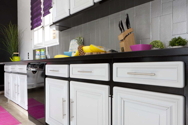 Repeindre les meubles de cuisine de deux couleurs, une idée sympa pour moderniser la cuisine. Avec la même peinture GripActiv V33 on en profite pour repeindre le carrelage de la crédence comme ici en gris Tourterelle qui s'harmonise avec le noir et blanc de la peinture sur les meubles