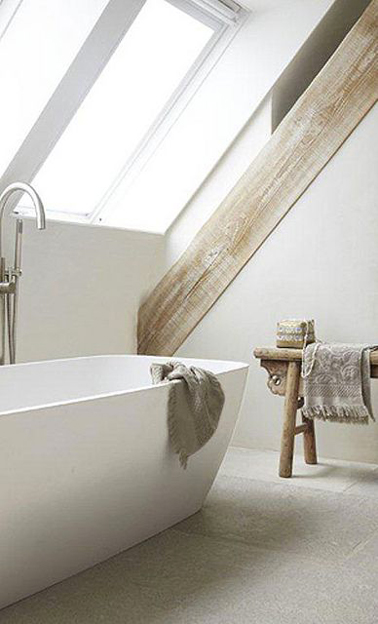 Salle de bain sous combles zen Dans cette salle de bain aménagée sous pente, pas d’artifice déco inutile ! Une baignoire balnéo, des murs blanc mettant en valeur les poutres blanchies, un tabouret en bois clair, tous les ingrédients sont réunis pour un bain zen