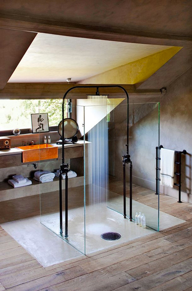 Une salle de bain sous les toits qui exploite la partie basse éclairée par le Vélux pour placer le meuble vasque ce qui permet d'avoir la douche italienne fermée par 4 parois de verres au centre de la pièce