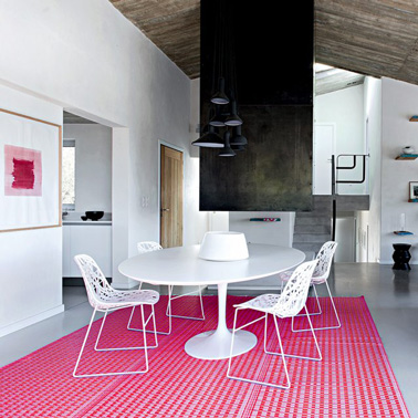Un sol rose dans le salon pour égayer une déco noir et blanc, avec ce tapis Fly aux motifs graphiques 