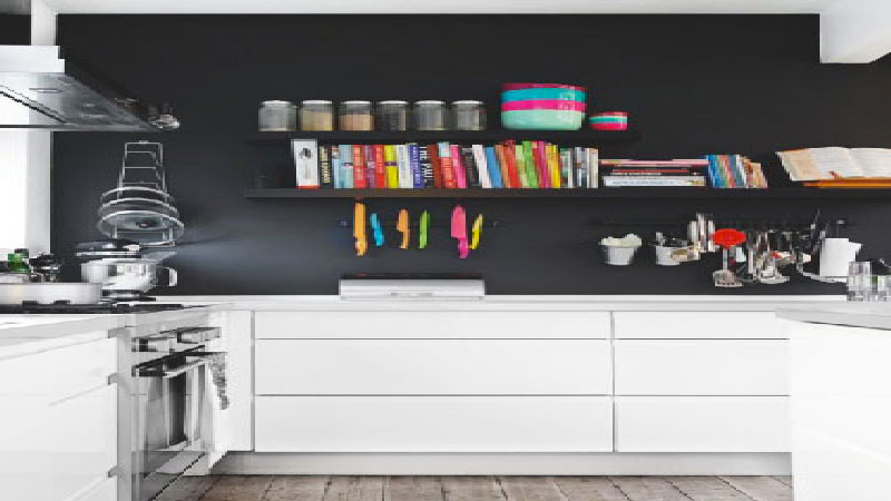 une peinture noire sur un pan de mur d'une cuisine blanche, une tendance pour une décoration de cuisine design. L'élégance de la couleur noire et du blanc pour une déco cuisine moderne, de style urbain ou industriel.