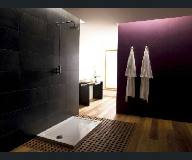 Une chambre parentale design avec un espace douche italienne ouvert sur la chambre. le receveur de douche XXL est posé sur un caillebotis encastré dans le parquet bambou.