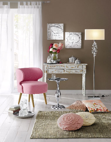 Un fauteuil rose blush aux pieds en hêtre dans une déco salon à dominante de couleur noyer. Une harmonie réussie entre une couleur plutôt vive et une déco chaleureuse plus en retenue.