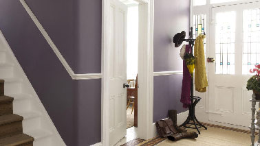 Une harmonie de teintes riches et intimes pour une entrée accueillante. L'aubergine subtilement associé à un violet terreux sur le soubassement révèle son effet sophistiqué au côté du blanc cassé en finition satinée des boiseries et des touches de gris apportés pour les meubles repeints. Peinture : Collection Crème de Couleur Dulux Valentine