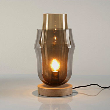 Cette lampe design à poser pour la chambre à double parois et bas en bois est original et efficace. La surperposition de la même matière, le verre, dans deux teintes différentes es une idée ingénieuse.