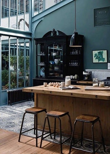 Le bleu pétrole offre à toutes les pièces une certaine classe. Dans cette cuisine aux murs et verrière bleu des meubles en bois un style industriel chic gagne la cuisine.