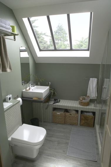  Une petite salle de bain de 4.5 m2 à l’aménagement pratique. Lumineuse grâce au puits de lumière, plan vasque plutôt qu’un meuble et banc maçonné prolongeant la douche. 