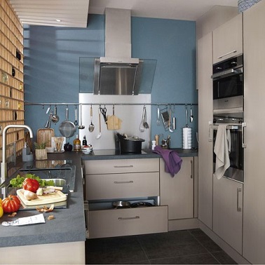Un look simple pour cette cuisine taille réduite. Des meubles de rangements blancs Leroy Merlin pour le côté pratique et fonctionnel de la pièce. Le pan de mur bleu gris et le plan de travail bleuté se suffisent à eux mêmes pour donner l'originalité et la note design à la cuisine. Petit plus astuce déco : le bleu gris sur un pan de mur à la vertu d'agrandir la cuisine et lui donner une nouvelle dimension.