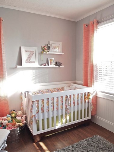 une chambre de bébé gris et corail très gaie pour une petite fille Un mur gris et des rideaux corail, il n’en faut pas plus pour faire de cette chambre bébé fille un endroit délicat à souhait ! Le petit lit blanc s’installe parfaitement dans cette pièce sobrement aménagée avec de petites étagères pratiques et décoratives au dessus de la couche taille réduite. De quoi déposer des cadres photos et autres jouets pour compléter l’ambiance mignonne de cette déco.