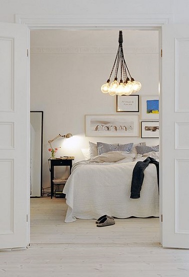 Comme une bulle de douceur, cette chambre parentale appelle à une ambiance cocooning. La couleur blanc qui prédomine dans la pièce lui confère un esprit zen épuré très tendance. La simplicité de la déco offre une atmosphère raffinée à la pièce. Pendant que le lit haut appelle le repos, quelques accessoires déco notamment les luminaires apportent de la modernité à cette chambre adulte.