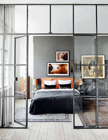 Une verrière design pour fermer cette chambre parentale et une luminosité qui met en valeur tout l’espace, voilà les atouts charme de cette pièce. Affublée d’un parquet en bois très clair d’un mur gris la déco est relevé par des éléments forts mettant en exergue l’ambiance zen. Des tapis qui semblent avoir été chinés dans un autre pays, une parure de lit noire et orange et des cadres invitant au voyage, les accessoires de cette chambre adulte marquent de leur empreinte zen toute l’atmosphère. 