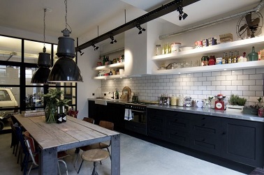 Le noir et blanc souligne élégamment et sobrement le design industriel de cette cuisine. Les luminaires suspensions vintage et barre de spots style usine accessoirisent la pièce et la pare d’une ambiance atelier chic. Mais l’atout majeur de cette cuisine est sans hésitation la table aux allures d’établi. Son plan de travail en bois ancien et sa structure en fer forment un tout, indus’ à souhait ! 