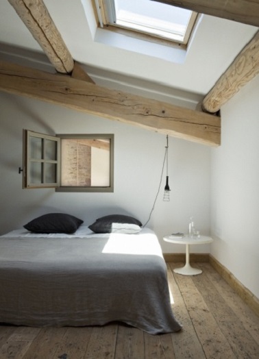 Sobriété et simplicité règnent dans cette chambre blanche. Profitant des poutres apparentes et du parquet chaleureux les murs passés au badigeon blanc sont dépouillés de tout artifice unitile