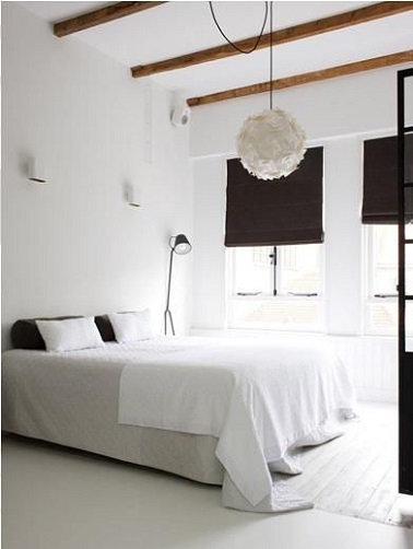Design avec du blanc dans la chambre Une chambre design grâce à l'association harmonieuse d’une peinture blanche avec des stores tissus et des coussins chocolat. Le parquet blanc renforce la luminosité et la sérénité de cette chambre parentale
