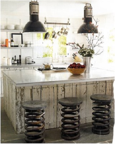 design industriel dans cette cuisine blanche Des tabourets en forme de ressorts géants en acier usé et des luminaires imposants, voilà les éléments forts de cette déco de cuisine industrielle. Pour alléger l’ensemble de la pièce, l’îlot central s’est paré de bois patiné avec une teinte claire et lumineuse. Un décor indus’ appuyé tout en étant subtil symbolisant parfaitement la nuance paradoxale entre ambiance brute et légèreté.