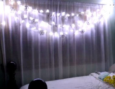 A l'aide de fleur artificielles, d'ornements, et d'une guirlande lumineuse fabriquez cette guirlande lumineuse pour mettre de la lumière sur vos rideaux.