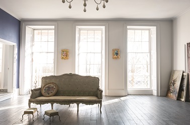 Entre gris et lin cette teinte de peinture dégage dans le salon une ambiance en tout point paisible. Un parquet chêne, un pan de mur peint en bleu, un canapé Louis XV et le chic prend place dans le salon. Peinture Farrow & Ball couleur Dimpse. 