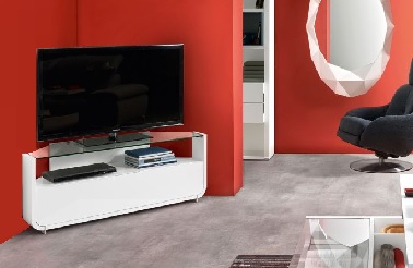 Un meuble TV blanc d'angle apaisant l'ambiance de ce salon rouge Ce meuble est idéal pour amener de la légèreté à une pièce déjà forte de caractère. En effet, la peinture rouge des murs, très affirmée, trouve un contraste apaisant dans des accessoires et meubles déco aux tons neutres et sobres. Ainsi le meuble T.V blanc Gautier se marie harmonieusement avec l’ensemble du mobilier aérien qui compose la pièce tels que la table basse blanche et verre que l’on devine au premier plan ou encore le grand miroir graphique blanc qui a pour effet d’agrandir le salon. ©Gautier - Collection Setis.