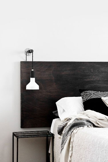 Déco moderne et pas chère pour la chambre avec cette tête de lit à fabriquer avec une simple planche peinte noir jais puis fixée au mur à l'aide de 4 vis. 