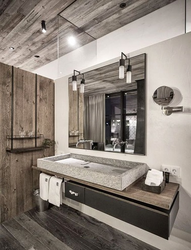 Une salle de bain qui réussit à marier l’authenticité des planches de bois et la modernité du meuble et vasque en pierre pour créer une ambiance originale et chaleureuse