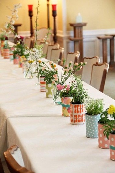 Un chemin de table en boîtes de conserve réutilisées, une astuce déco pour Pâques Ne jetez plus vos vieilles boites de conserve elles pourraient vous être bien utiles pour décorer votre table de Pâques ! Après les avoir soigneusement nettoyées, brossez l’acier des boîtes afin de pouvoir bien coller un morceau de papier bariolé autour d’elles. Une fois fait, laissez sécher et remplissez les boîtes de conserve avec du terreau humide et plantez-y quelques fleurs et autres plantes vertes pour créer un chemin de table original et naturel. Rapide à réaliser cette déco est parfaite pour celles et ceux qui manquerait de temps pour bien décorer leur table de Pâques. Source photo : mycraftilyeverafter.com