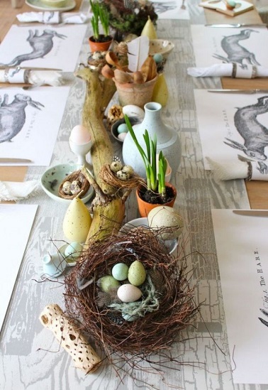 Mélange harmonieux d'objets déco naturels pour cette déco de table de Pâques Si cette déco de table peut sembler un peu désorganisée, il n'en est rien. Chaque élément de la table trouve sa place au bon endroit pour se conjuguer harmonieusement avec le reste des objets déco issus de récup. Un nid en bout de table rappelle le thème pascal pendant que d’autres objets natures comme la grande branche en bois flotté et les plantes en pots amènent la touche printanière à toute la déco. Une table qui ne peut être que le théâtre de grands moments de convivialité en famille ou entre amis pour le jour de Pâques. Source : deavita.fr