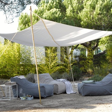 Entre voile d'ombrage et auvent, cette toile écru en coton apporte de l'exotisme chic au jardin. La Redoute Tendu par des cordelettes tressées et arrimé au sol grâce à des poteaux en bambou, ce voile d’ombrage en coton couleur écru apporte un air d’exotisme à l’extérieur. Sa forme carrée qui fait penser à celle d’un auvent permet de mettre à l’ombre une plus grande surface. Très léger, cette toile d’ombrage est parfaite pour profiter du jardin et rendre l’espace détente du jardin un peu plus raffiné. Auvent Toubou (existe en bleu cobalt, gris éléphant et écru)– AM.PM – La Redoute – 99 euros.