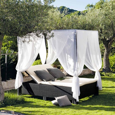 Un bain de soleil double aux allures de lit à baldaquin moderne et confort - Maisons du Monde Combinaison confortable et élégante d'un lit de jardin à baldaquin et d'un transat contemporain, ce bain de soleil crée dans le jardin ou sur la terrasse un vrai espace détente. Le duo de couleur sobre composé de la structure tressée noire et du revêtement en tissu blanc apporte un design moderne pendant que les voilages blancs amènent, eux, la fraîcheur et la légèreté à ce joli bain de soleil. Plus pratique qu’un lit qui ne permet que la position allongée, ce transat double propose plusieurs inclinaisons. Parfait pour bouquiner tranquille ou faire une sieste ce lit détente s’associe également avec d’autres meubles de jardin de la même gamme pour former un salon de jardin exquis pour l’été ! Maisons Du Monde - MIAMI Lit à baldaquin d'extérieur - Dimensions (cm) : H 210 x L 210 x PR 150 – Prix : 999,90 euros.